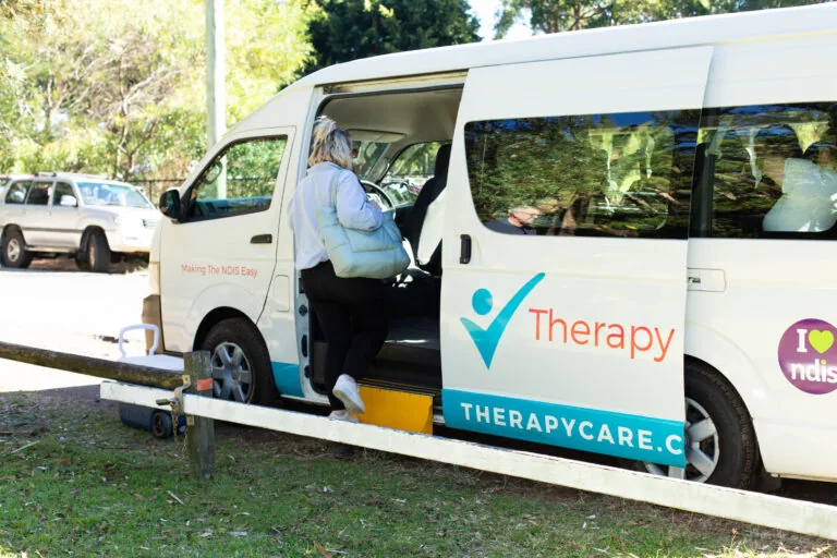 A Therapy Care van parked at a beachside park on a day out