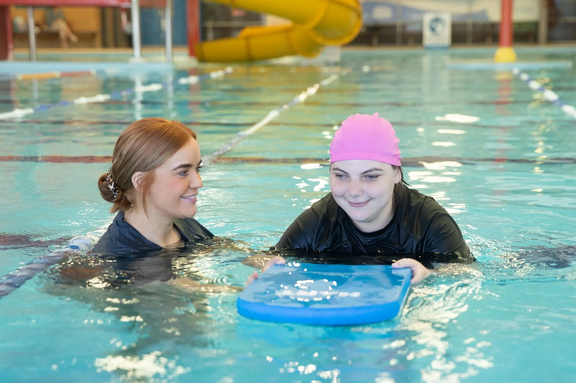 A therapist and a participant in the hydrotherapy pool with a kickboard